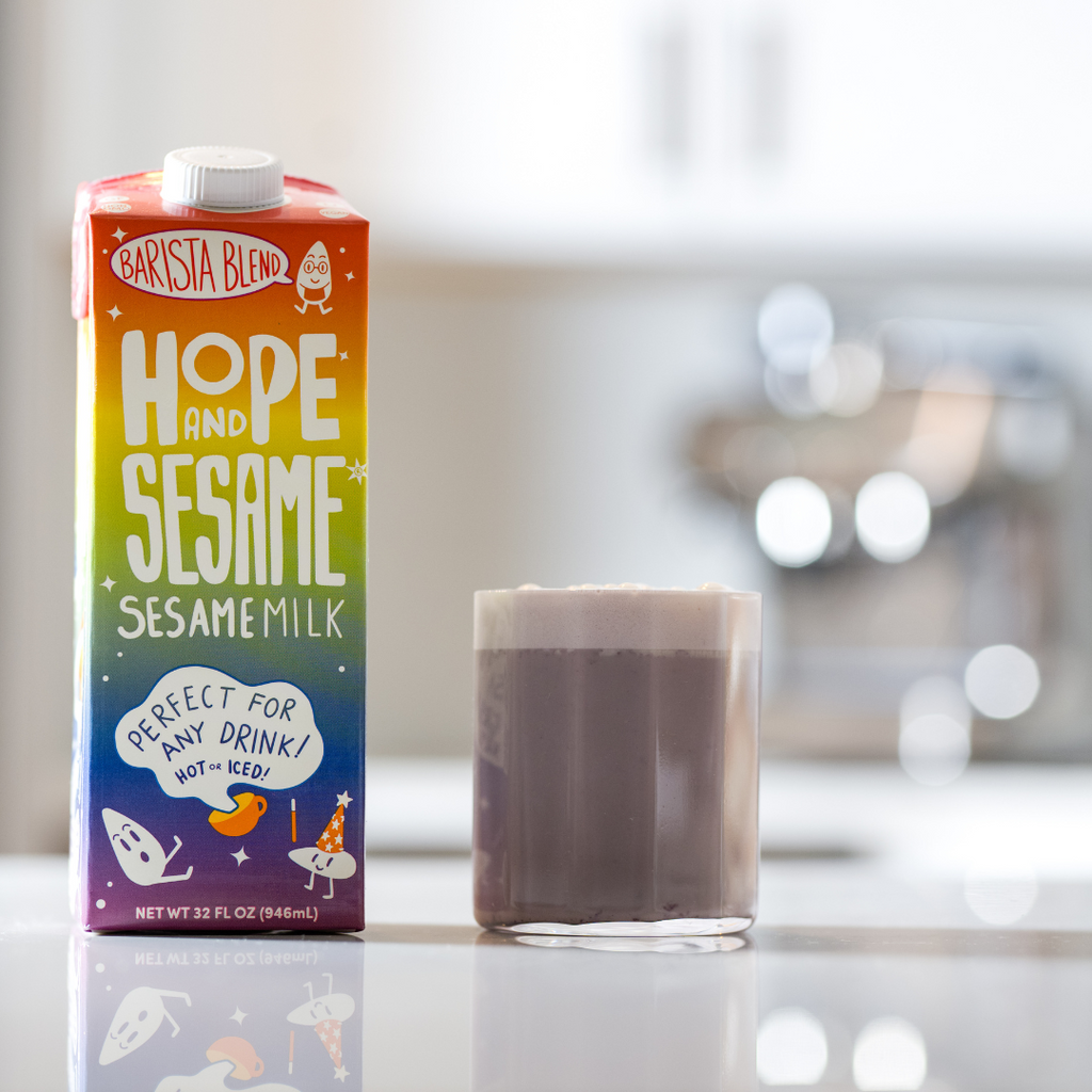 Short glass of Blueberry Chai Refresher with a carton of Hope and Sesame Barista Blend Sesamemilk