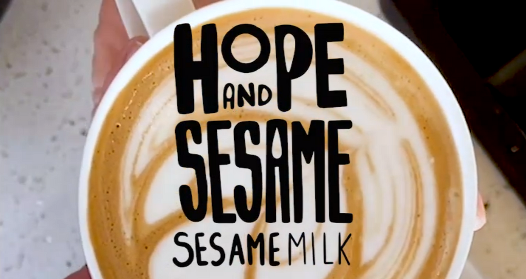 Dairy alternative Hope and Sesame Sesamemilk, black text logo over a mug of a latte