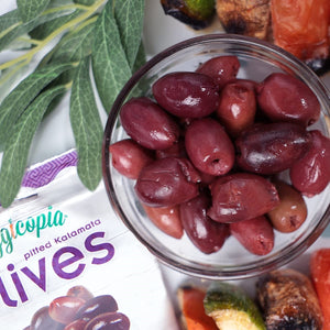 Veggicopia Olives with packet of pitted Kalamata and a glass bowl of olives 